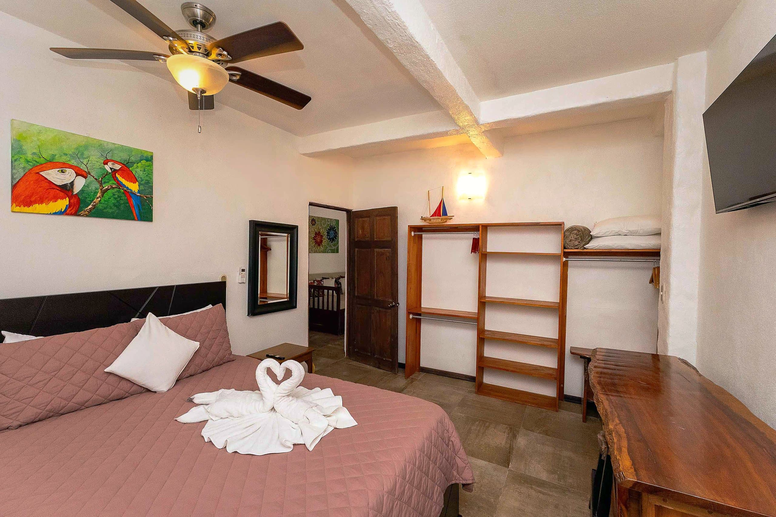 Bedroom with scarlet macaw painting and desk