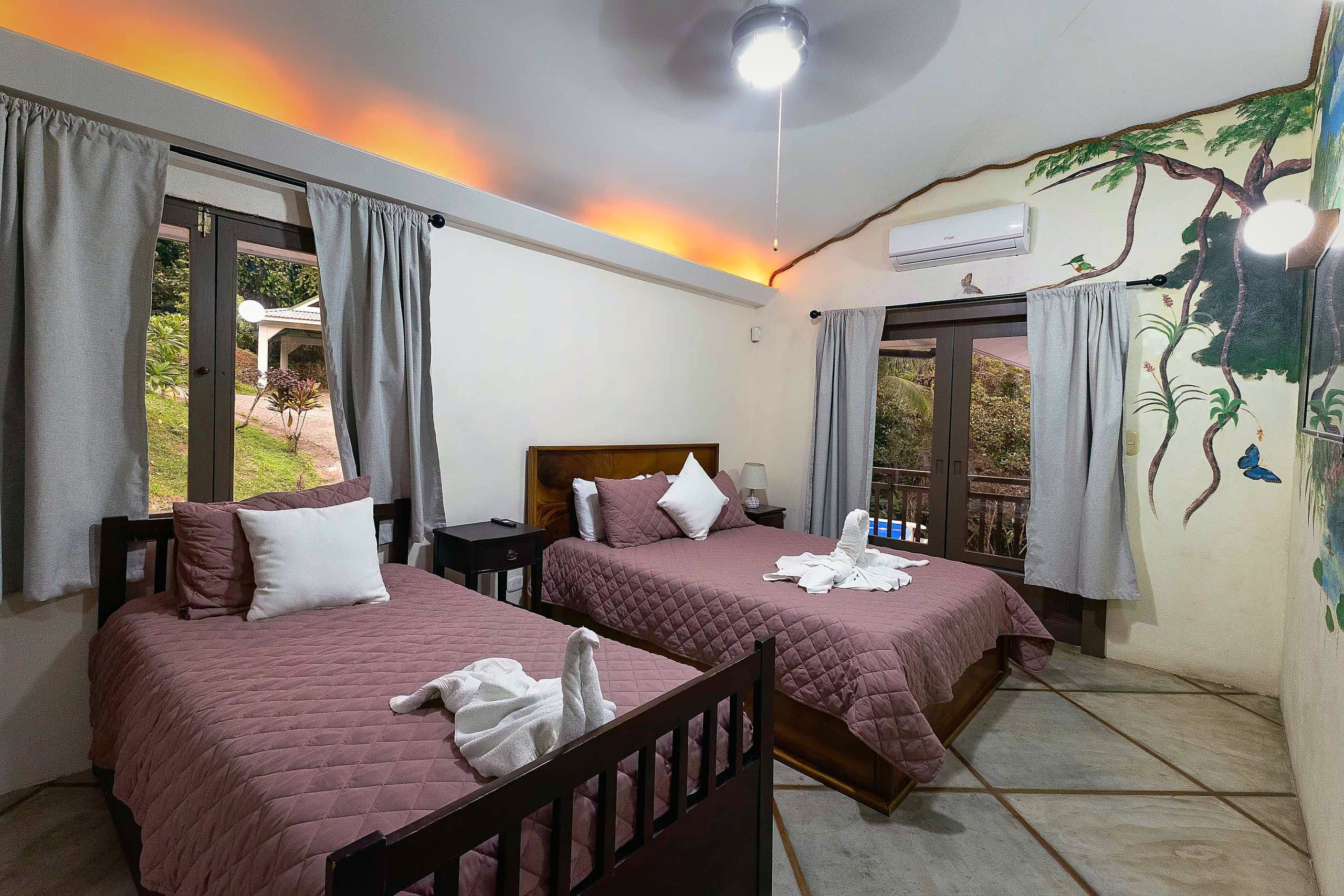 Bedroom with jungle mural and two beds