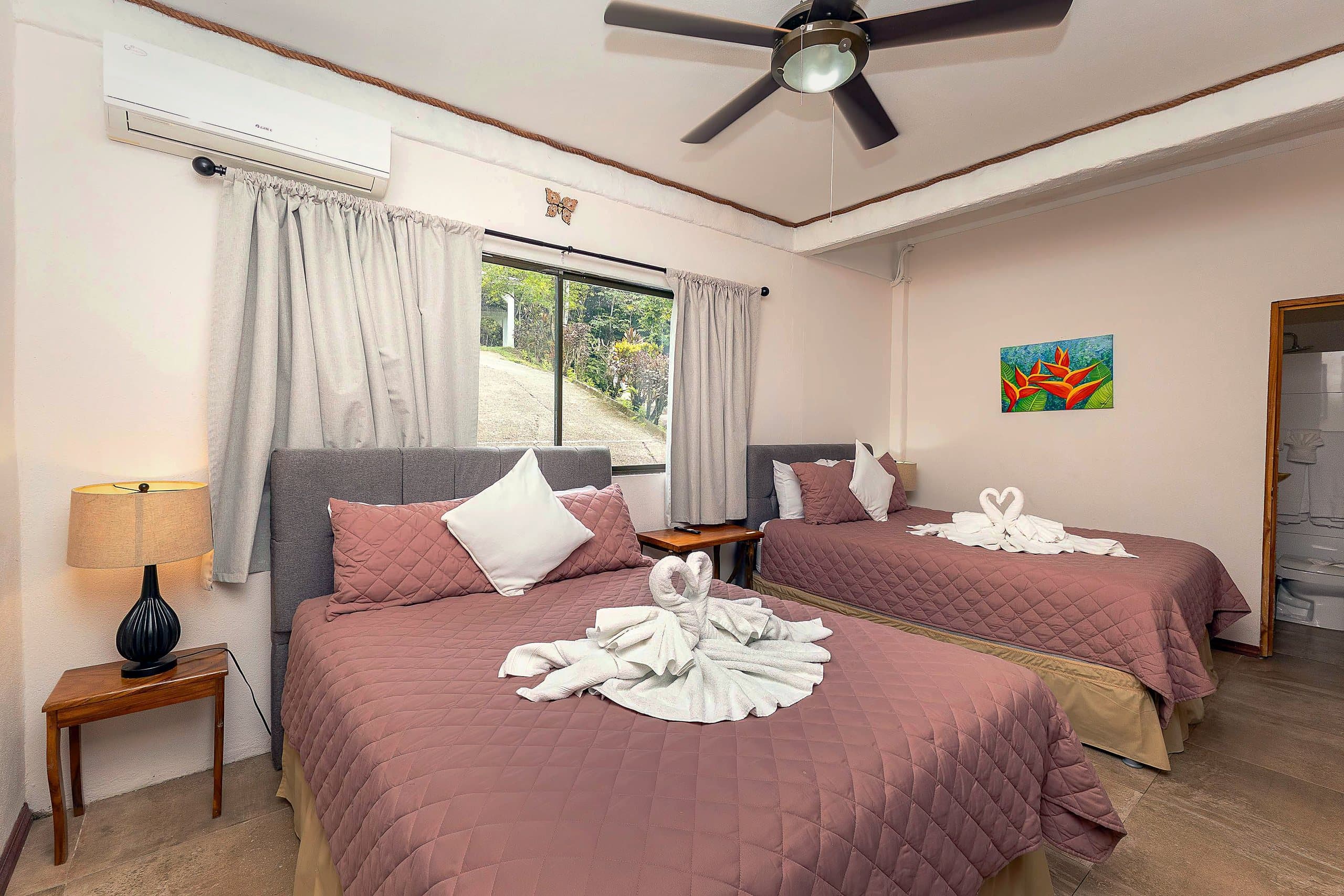 Bedroom with two beds and heliconia art